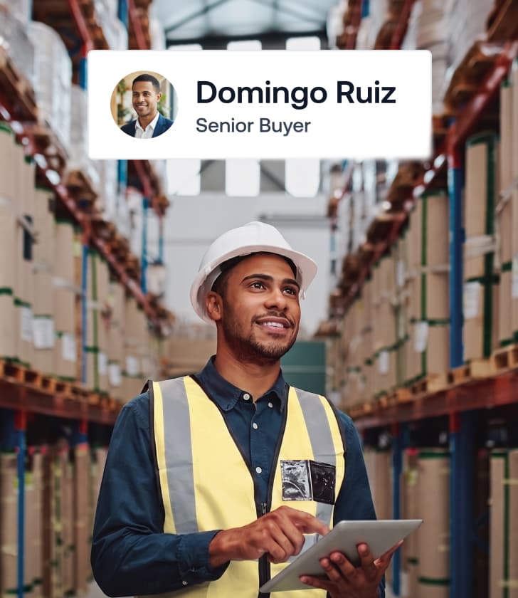 El comprador sénior Domingo Ruiz sostiene una tableta digital dentro de un gran almacén logístico.