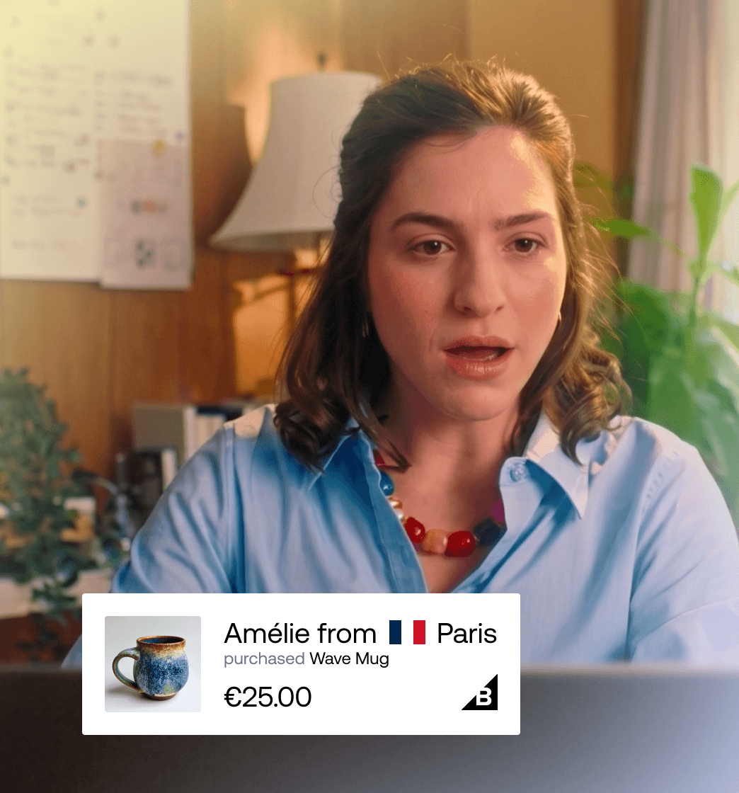 Mujer mirando una pantalla con una insignia de prueba social en tiempo real que muestra que Amélie, de París, ha comprado una taza Wave Mug por 25 €